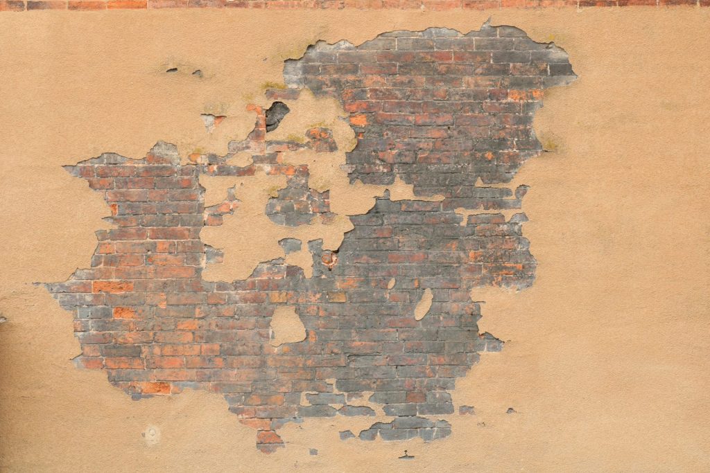 Ein Hydrant vor einer Ziegelwand.
