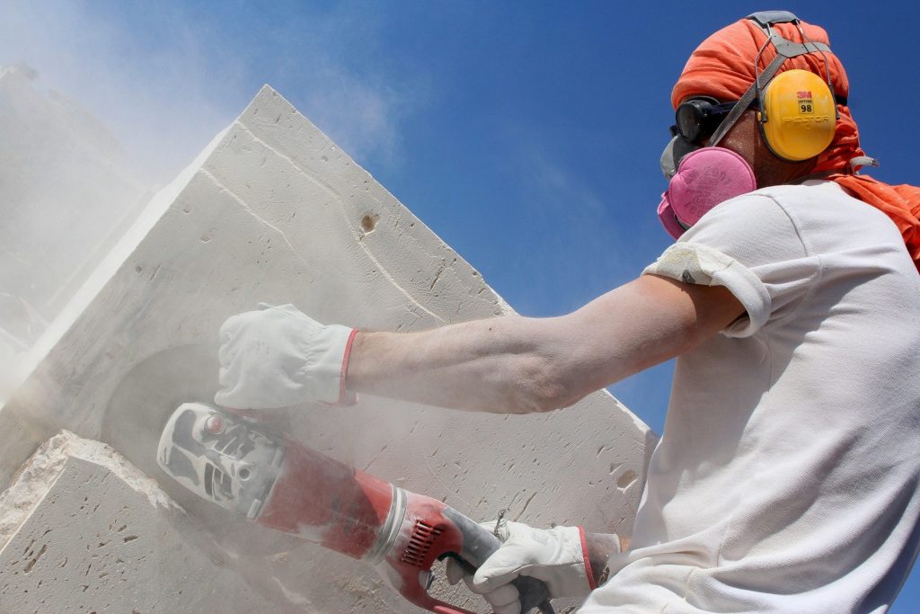 man holding angle grinder during daytime
